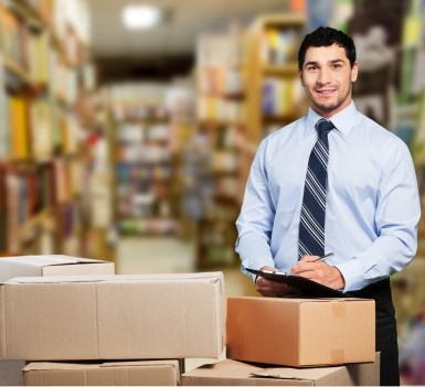 Business executive with tie doing inventory in a warehouse.
